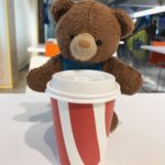Childhood stuffed bear drinking a large coffee in Australia