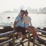 Taiwanese American and Australia young couple in Busan South Korea's Haeundae Beach taking a break and enjoying the water and skyline